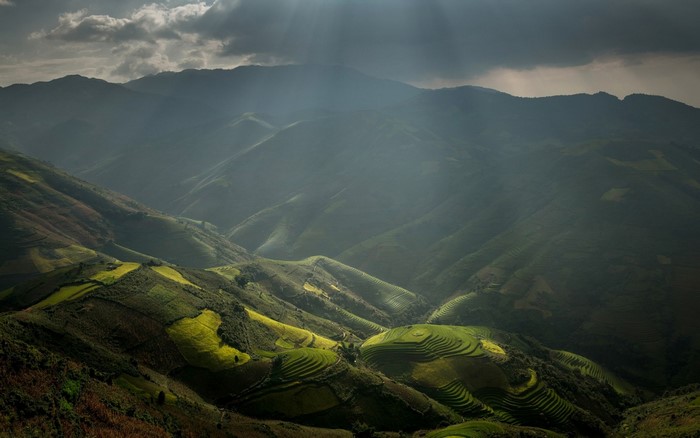 Sunlight over terraced rice paddies in a mountainous valley