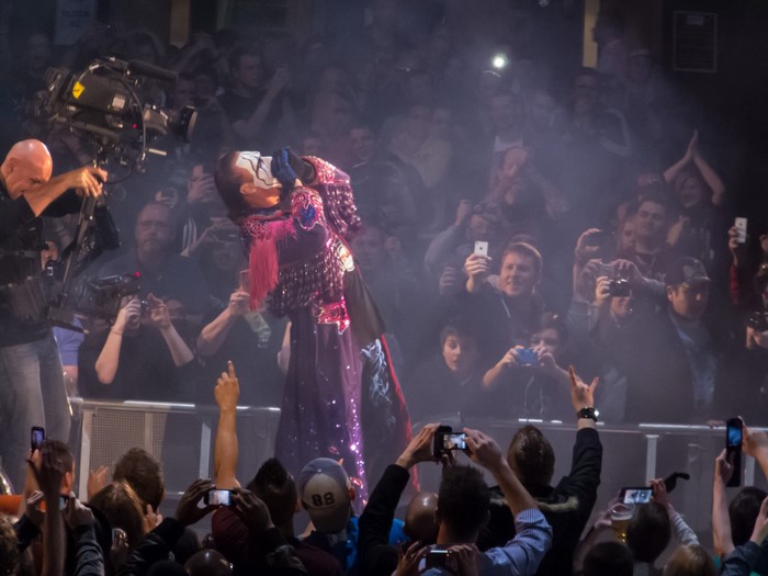 Performer with face paint on stage with crowd