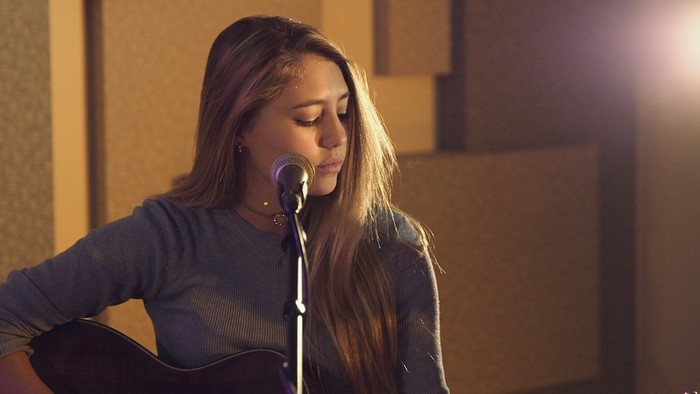Lia Marie Johnson singing into a microphone