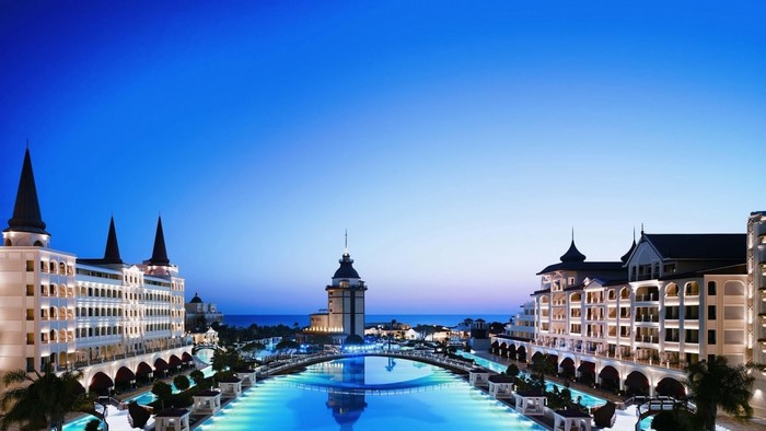 Luxury resort with waterways and illuminated buildings at dusk