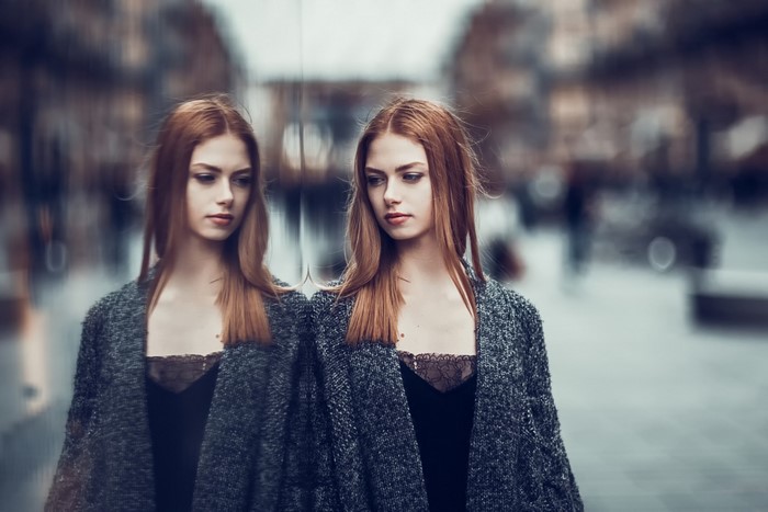 Woman with red hair reflected in a window