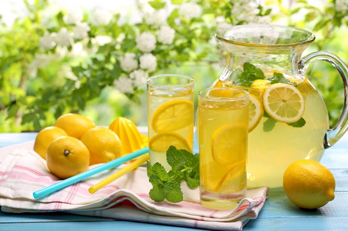 Pitcher and glasses of lemonade with lemons and mint