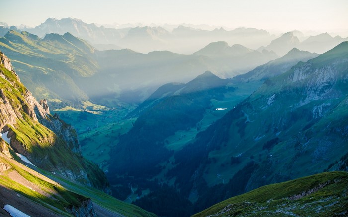 Misty mountain valley with a lake in Switzerland