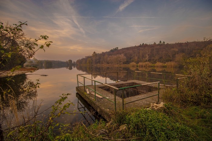 Concrete platform with railing on a lake at sunset