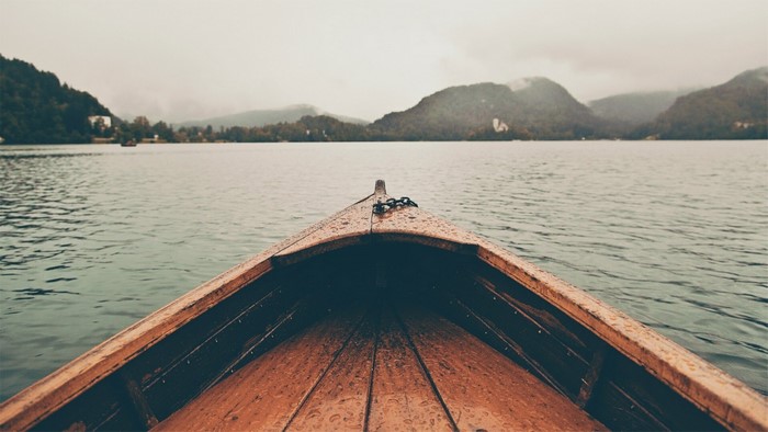 Wooden boat on a lake with mountains in the background