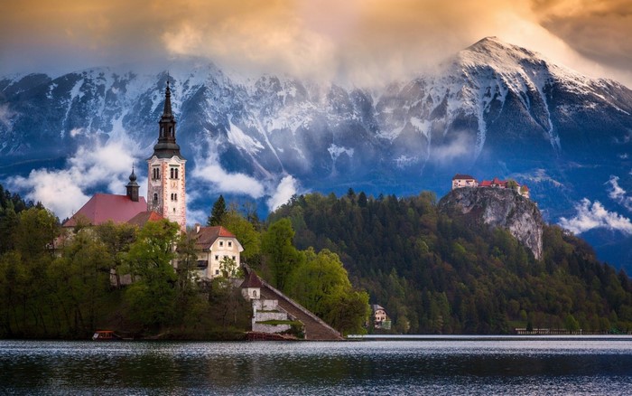 Church and castle on islands in a lake with mountains