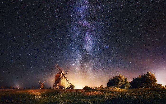 Night sky with Milky Way over windmills