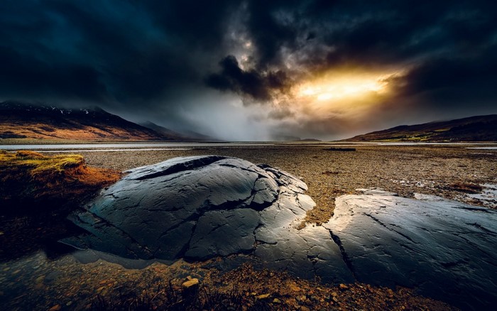 Dramatic landscape with stormy sky and sunlit mountains