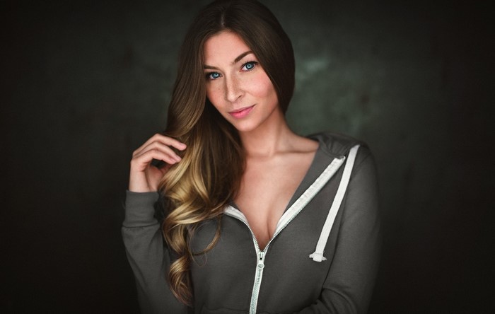Woman with long blonde hair wearing a grey hoodie