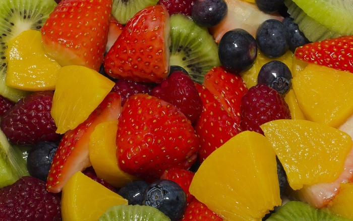Close-up of a fruit salad with strawberries, kiwi, mango, and blueberries