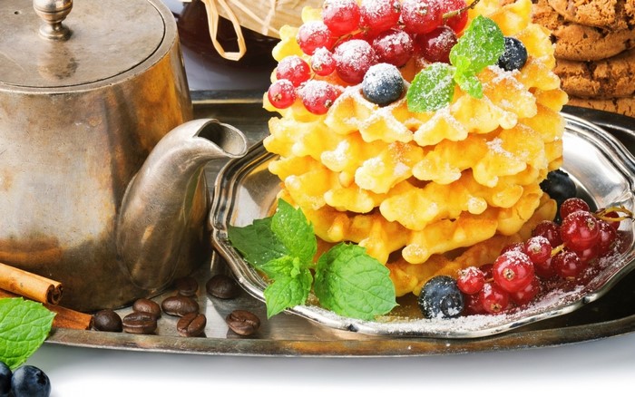 Waffles with berries and coffee on a tray
