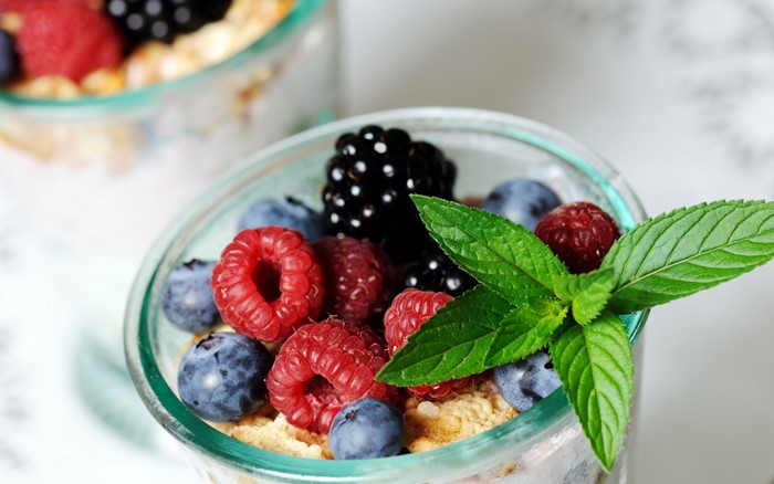 Close-up of a glass jar filled with berries and granola