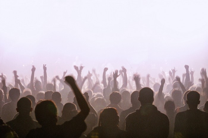 Crowd with hands raised in haze