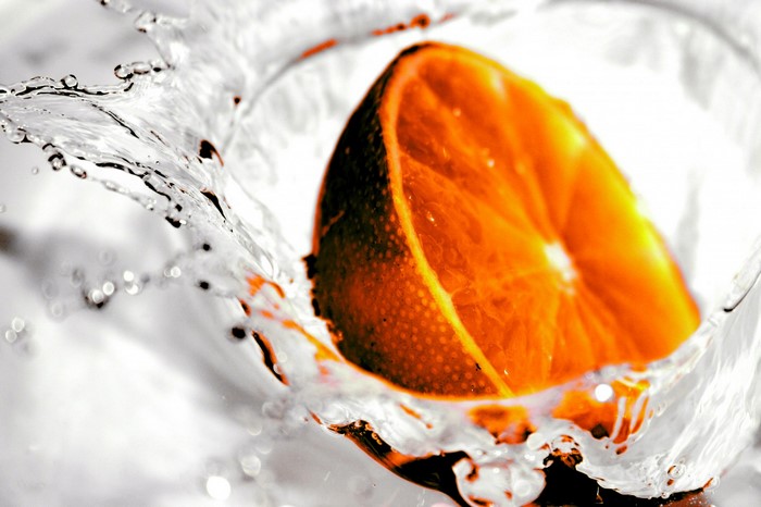 Orange slice splashing into water
