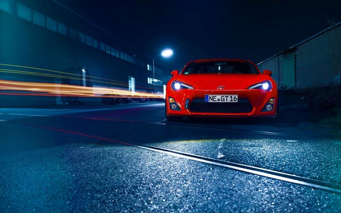 Red Toyota GT 86 sports car at night with light trails