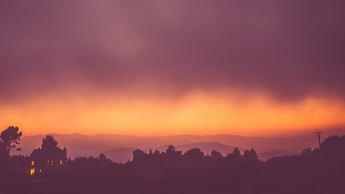 Sunset over mountains with a house