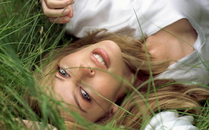 Woman lying in green grass
