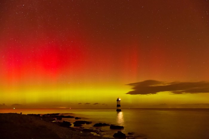 Aurora Borealis over the sea with a lighthouse