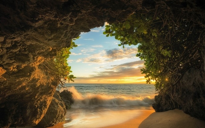 Sunset over the ocean viewed from a cave entrance