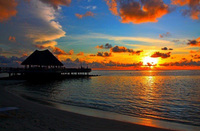 Sunset over the ocean with a pier and beach