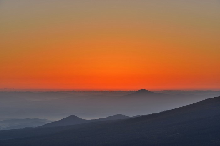 Mountain range at sunset with orange sky