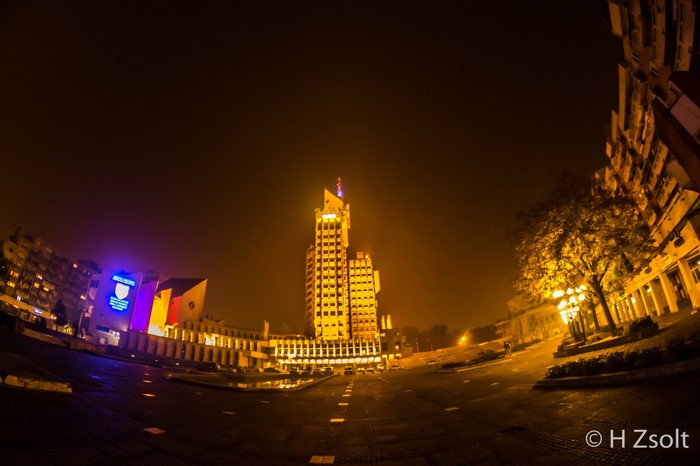 Cityscape at night with illuminated buildings and streetlights