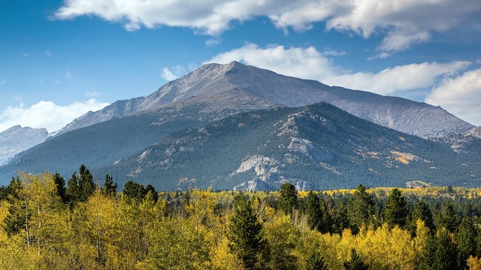 Mountain range with autumn trees and clouds