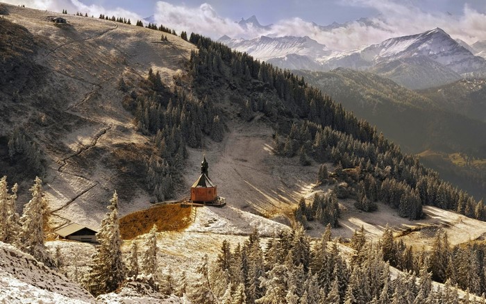 Chapel on a snowy mountain slope in the Alps