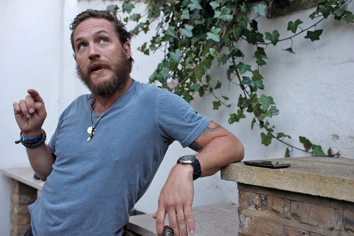 Tom Hardy wearing a blue t-shirt outdoors
