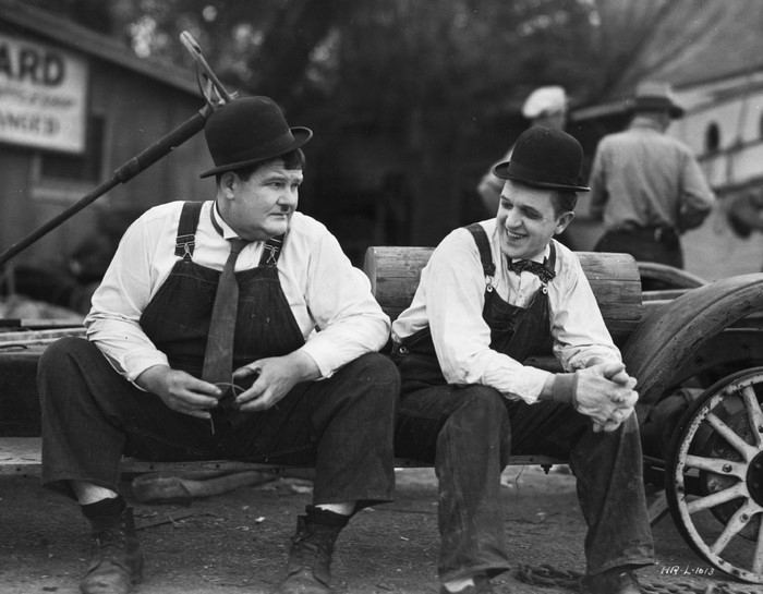 Laurel and Hardy sitting on a cart