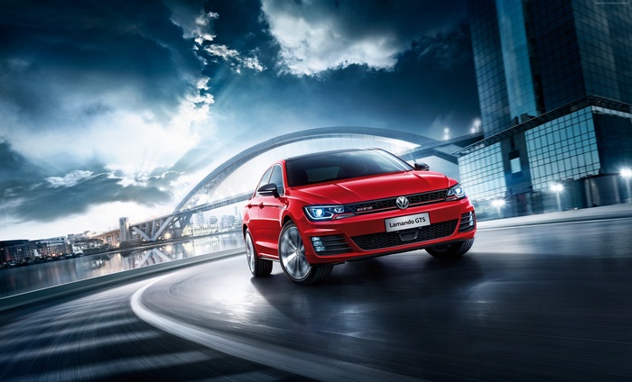 Red Volkswagen Lamando GTS driving on a curved road