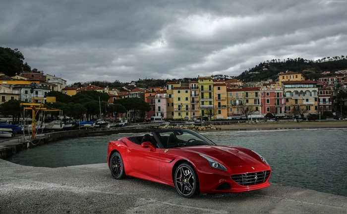 Red Ferrari California T HS convertible parked by the sea