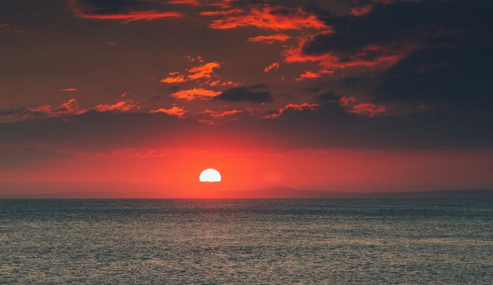 Sunset over the ocean with red clouds