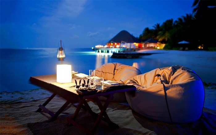 Romantic beach dinner at a tropical resort at dusk