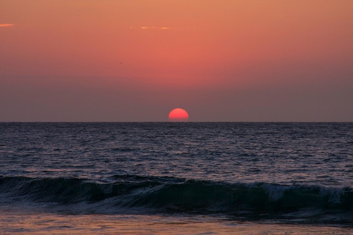 Sunset over the ocean with waves