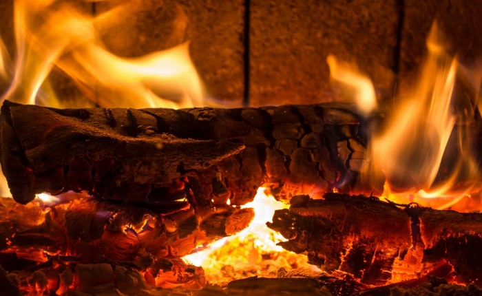Close-up of burning logs in a fireplace with flames