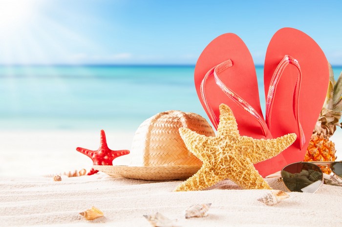 Beach scene with flip-flops, hat, and starfish