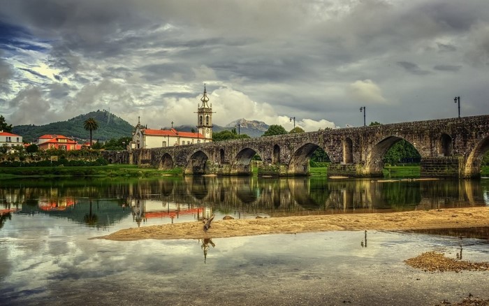 Stone bridge over a river with a church and town