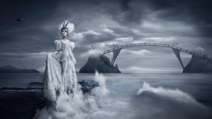 Woman in white dress on rocky shore with bridge and birds