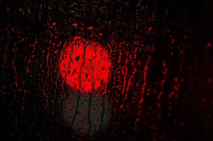 Red light through rain on glass