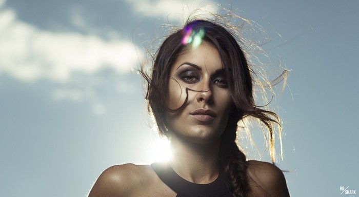 Woman with windblown hair against a blue sky