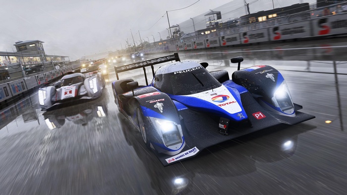 Peugeot and Audi race cars on wet track