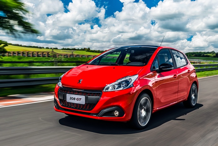 Red Peugeot 208 GT driving on a track