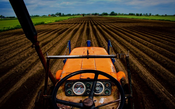 Tractor driving through a tilled field