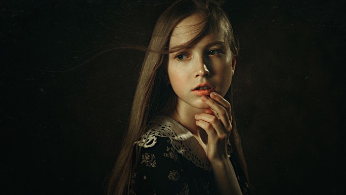 Young woman with long hair in a dark dress