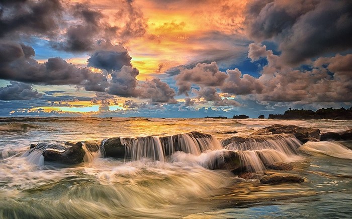 Sunset Over Bali Coastline with Dramatic Clouds