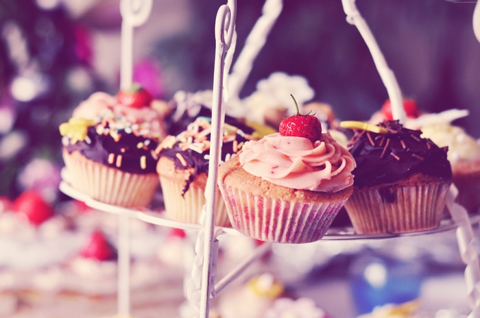 Cupcakes with cream and strawberry on a tiered stand