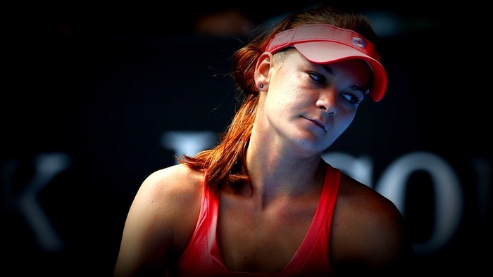 Agnieszka Radwańska wearing a red visor and top