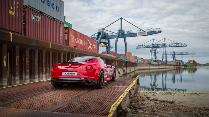 Red Alfa Romeo 4C sports car at a shipping port