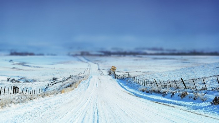 Snowy road with dead end sign in winter landscape